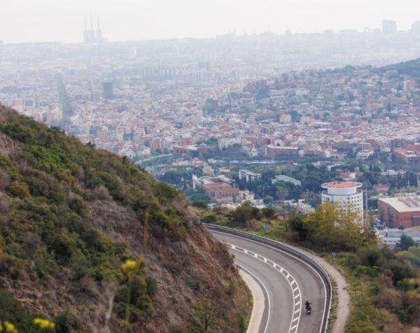 A motorcycle riding along a road high in the hills 